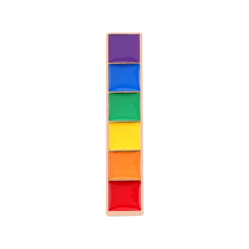 A rectangular Pride Flag Bar Pin by RainBee Designs LLC features six square watercolor-like colors—purple, blue, green, yellow, orange, and red—arranged vertically on a white background, resembling a vibrant rainbow.