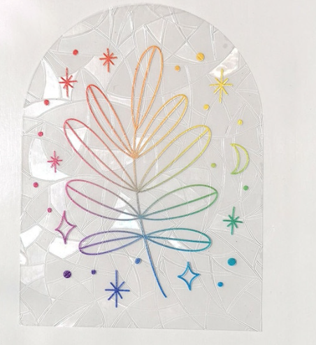 The Leaf Suncatcher by RainBee Designs LLC is a transparent arched window decal showcasing a rainbow-outlined leaf encircled by colorful stars, sparkles, and a crescent moon on a subtly textured white background.