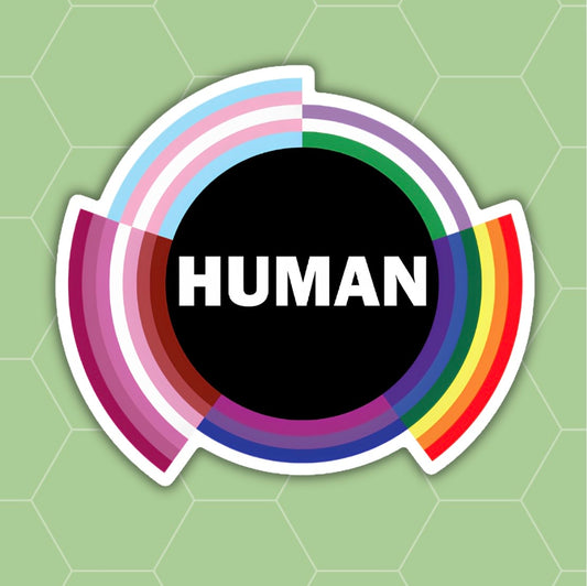 A die-cut sticker featuring the word 'HUMAN' in white capital letters inside a black circle, surrounded by concentric rainbow-colored arches on a light green hexagonal background.