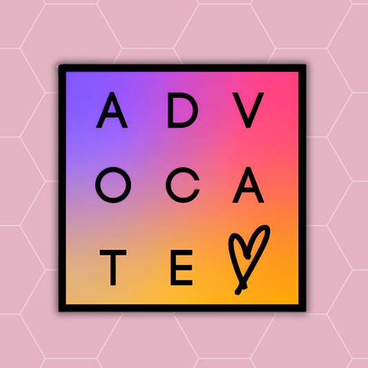 A square framed print featuring the word 'ADVOCATE' spelled out in large black letters over a pink-to-yellow gradient background, with a heart drawn in black at the bottom right. The print is centered on a light pink background with a subtle hexagonal pattern.