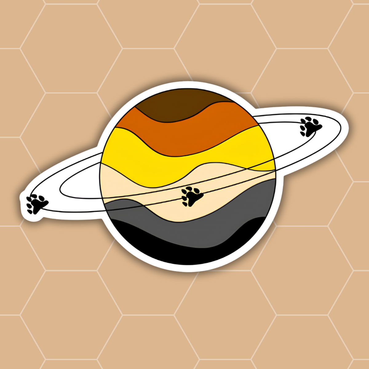 A die-cut vinyl sticker featuring a stylized Saturn-like planet with wavy horizontal bands in brown, orange, yellow, beige, gray, and black, plus a white ring with black paw-print accents, shown on a tan hexagonal patterned background.