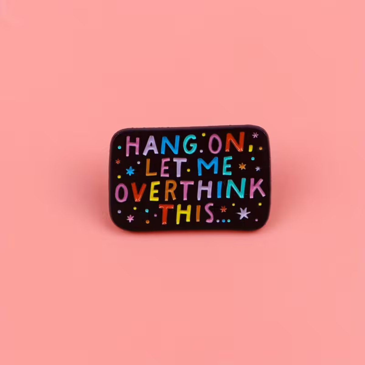 A rectangular black enamel pin with rounded corners featuring the phrase 'HANG ON LET ME OVERTHINK THIS.