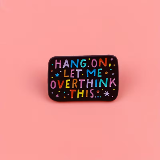 A rectangular black enamel pin with rounded corners featuring the phrase 'HANG ON LET ME OVERTHINK THIS.