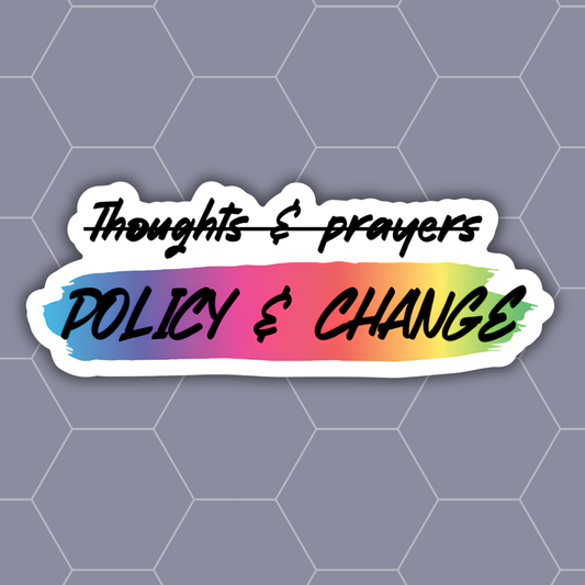 A die-cut vinyl sticker with a white border, featuring the text 'Thoughts & prayers' in black script crossed out above 'POLICY & CHANGE' in bold black letters over a blue-to-yellow rainbow gradient background, shown on a gray hexagonal patterned backdrop.