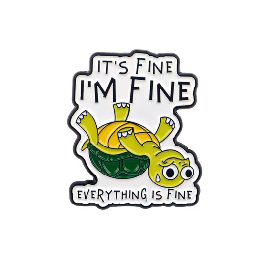A die-cut enamel pin featuring a cartoon turtle lying on its back inside a shell, with the text 'IT'S FINE I'M FINE' above and 'EVERYTHING IS FINE' below, on a plain white background.